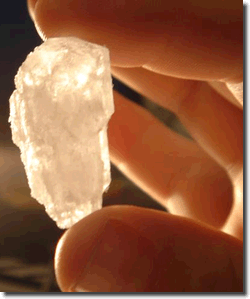 Fingers holding big meth crystal